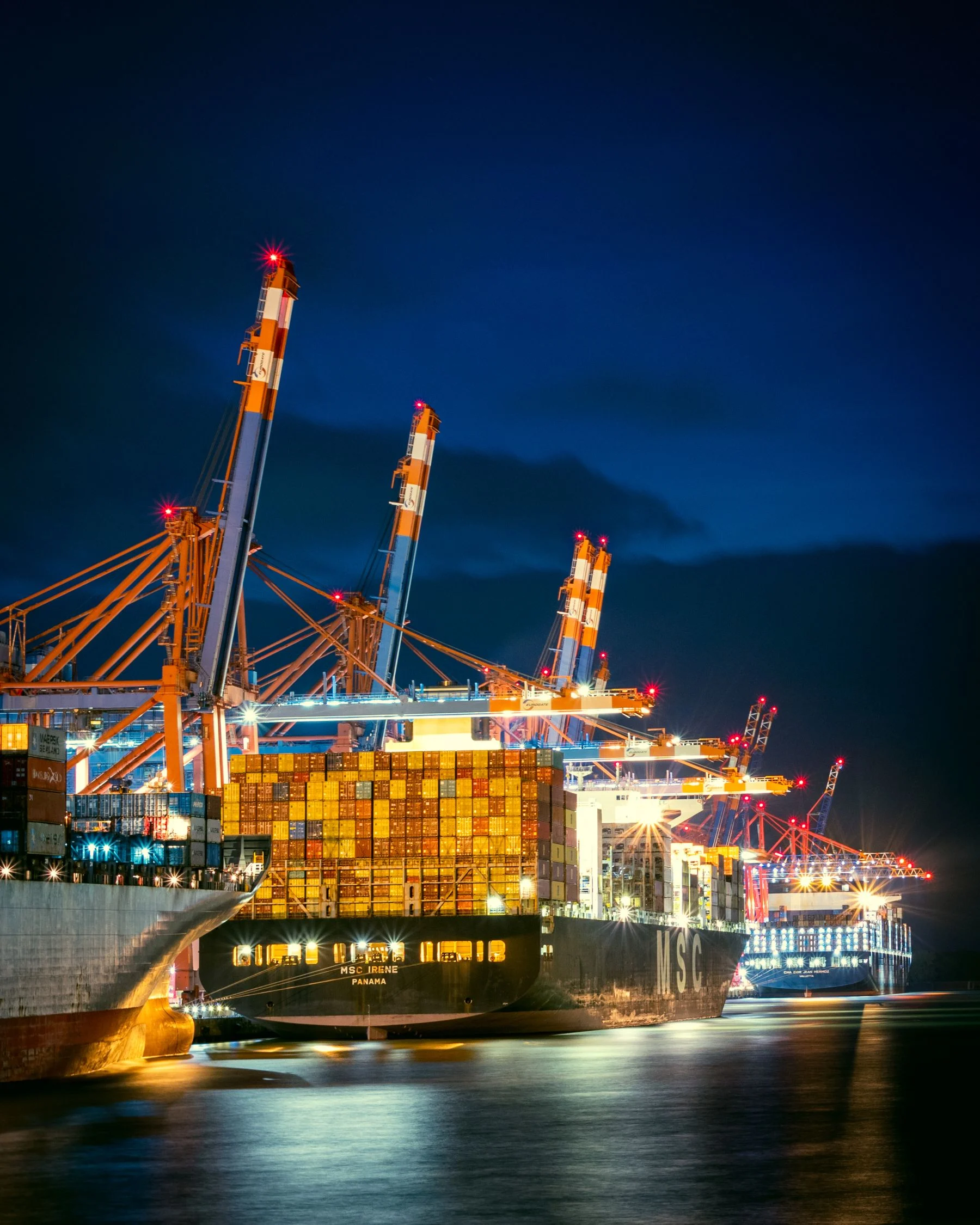 Container ships and port cranes at night